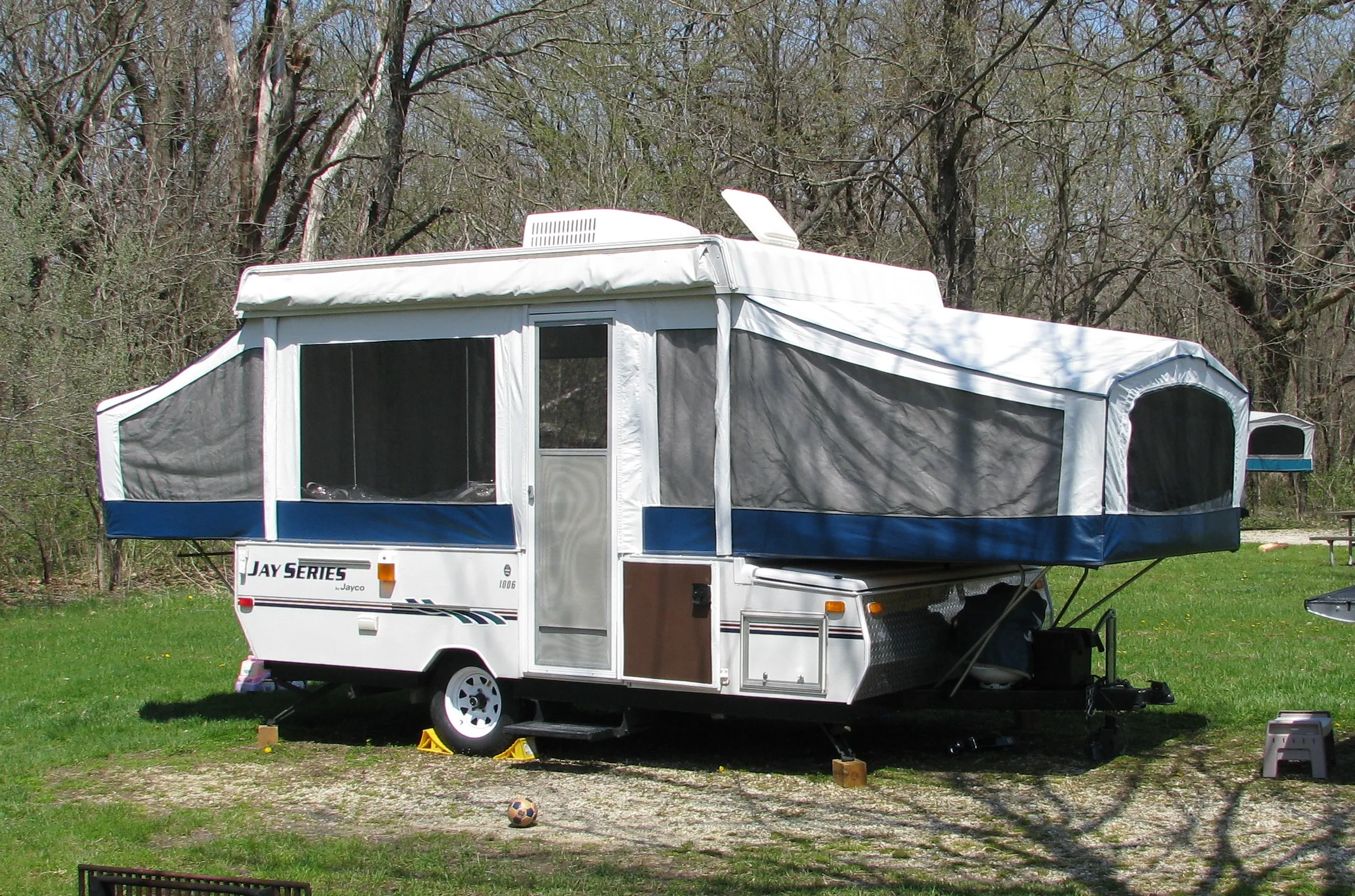 Jayco Jay Series popup camper set up at a shaded campground