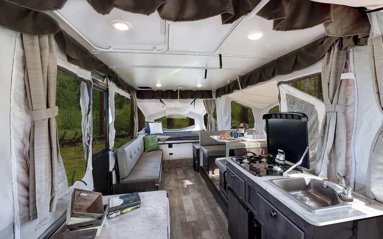Popup camper interior with kitchen, dinette and sleeping area